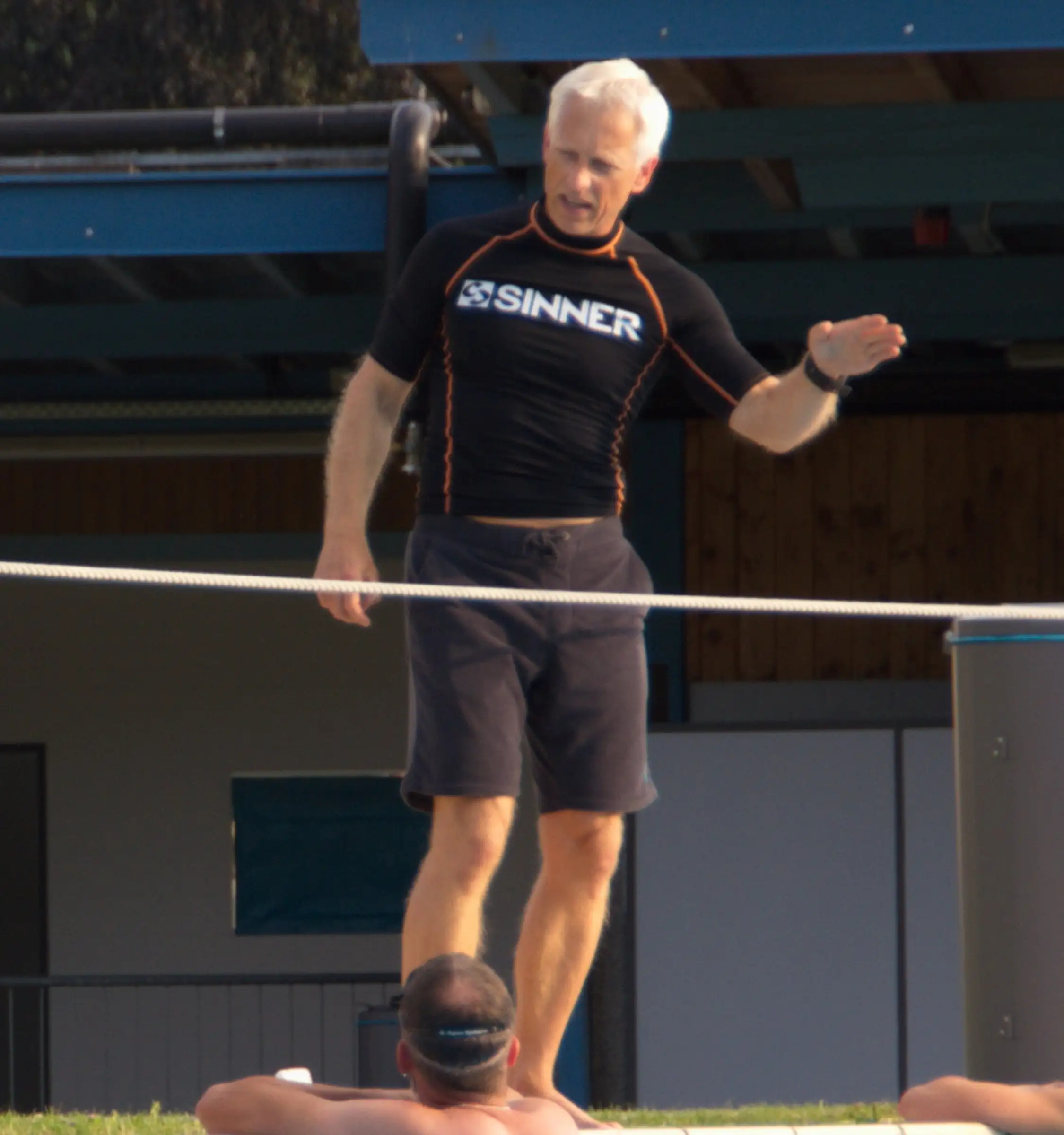 Uwe Schapeit steht am Freibad Elzach auf einer Slackline und erklärt mit ausgestrecktem Arm